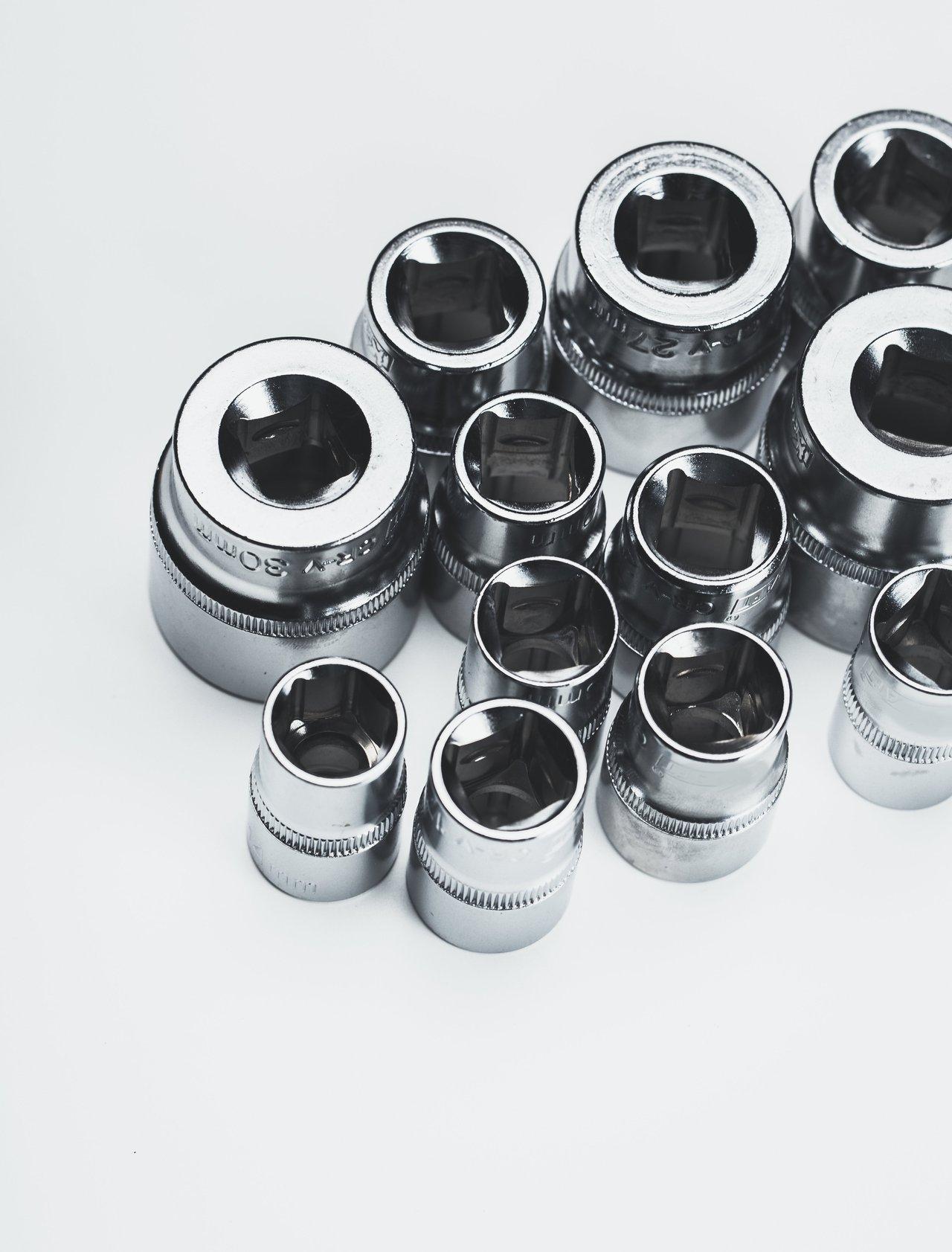 Accessoires de coffret de douilles à choc, essentiels pour l'automobile, disposés sur un établi.