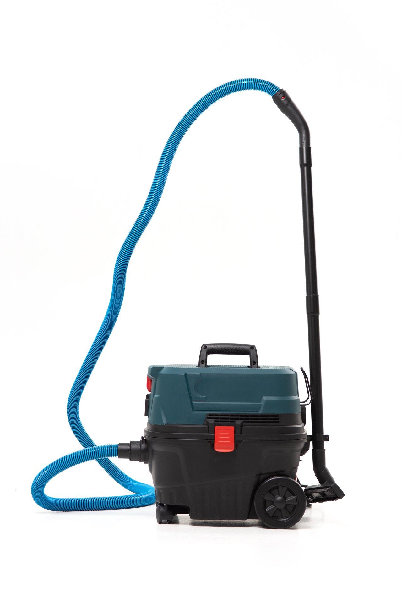 Aspirateur industriel avec outil électrique pour un nettoyage efficace et silencieux de la poussière de plâtre.