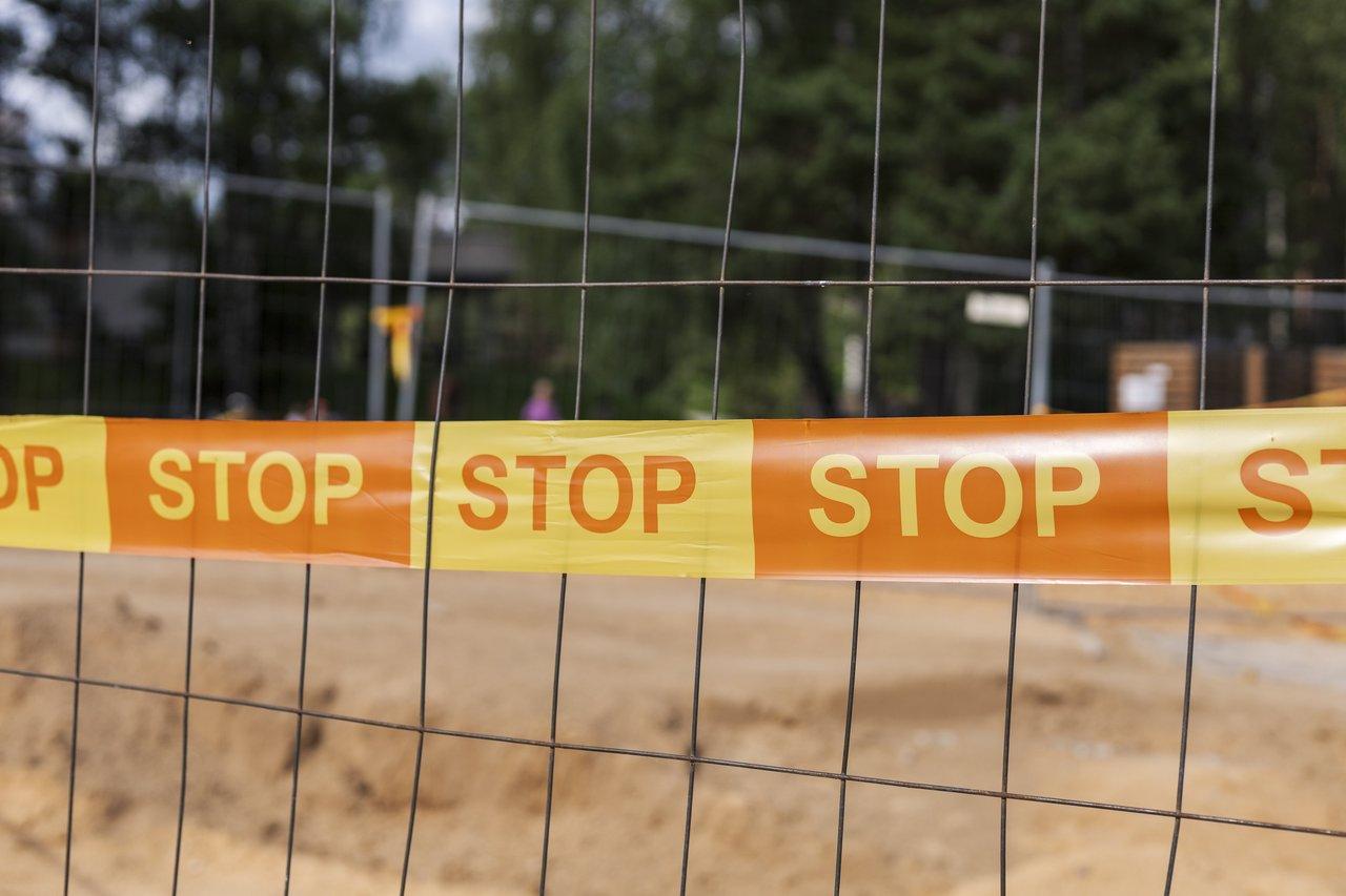 Barrières de sécurité sur un chantier de construction fermé au public, avec affichage et contrôle des EPI par les chefs.