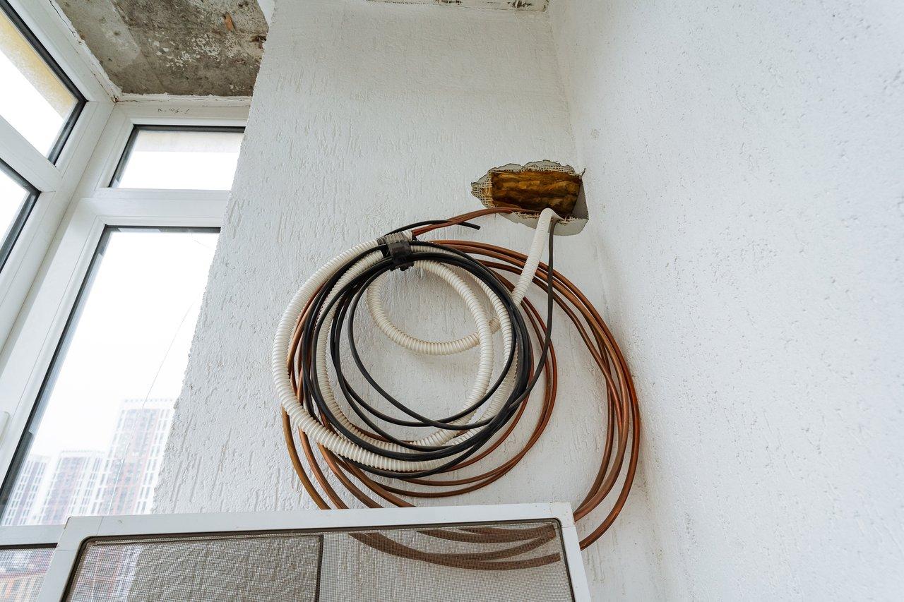 Bobine d’enroulement de rallonge électrique bien organisée sur support mural pour un rangement sécurisé et facile à utiliser.