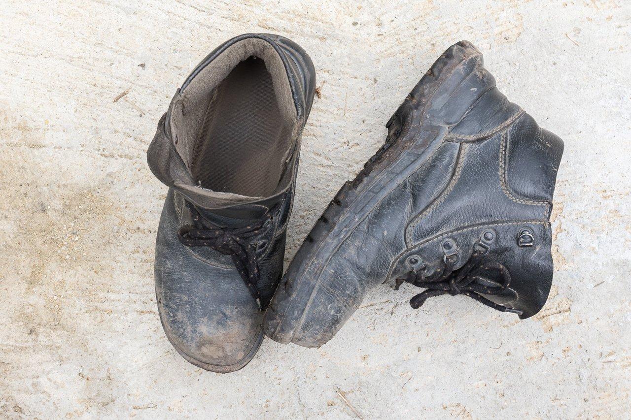 Chaussures de sécurité industrielles en cuir noir sur sol en béton, essentielles pour prévenir les accidents.