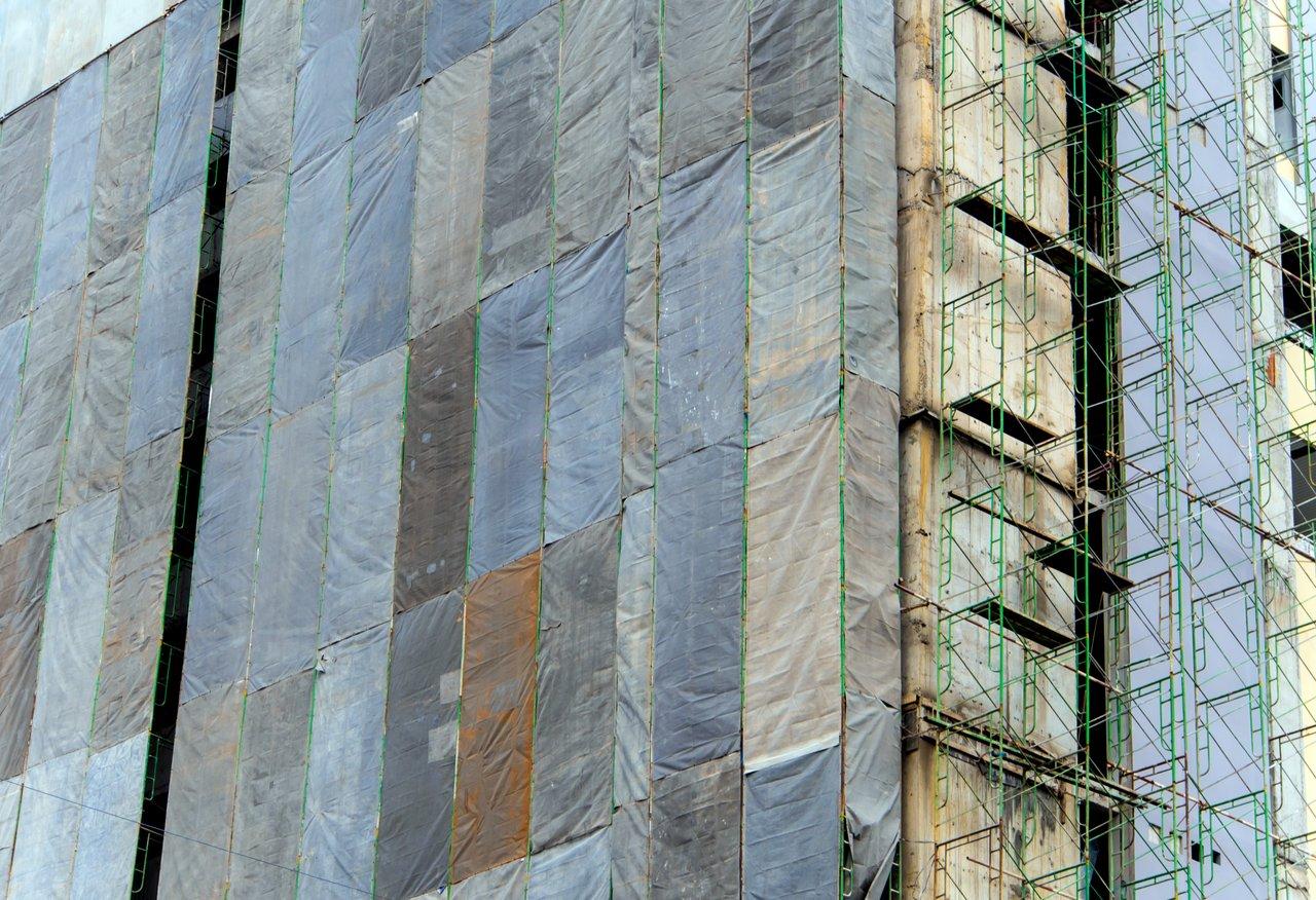 Échafaudage couvert en automne sous pluie légère pour protéger le chantier et prévenir l’humidité.