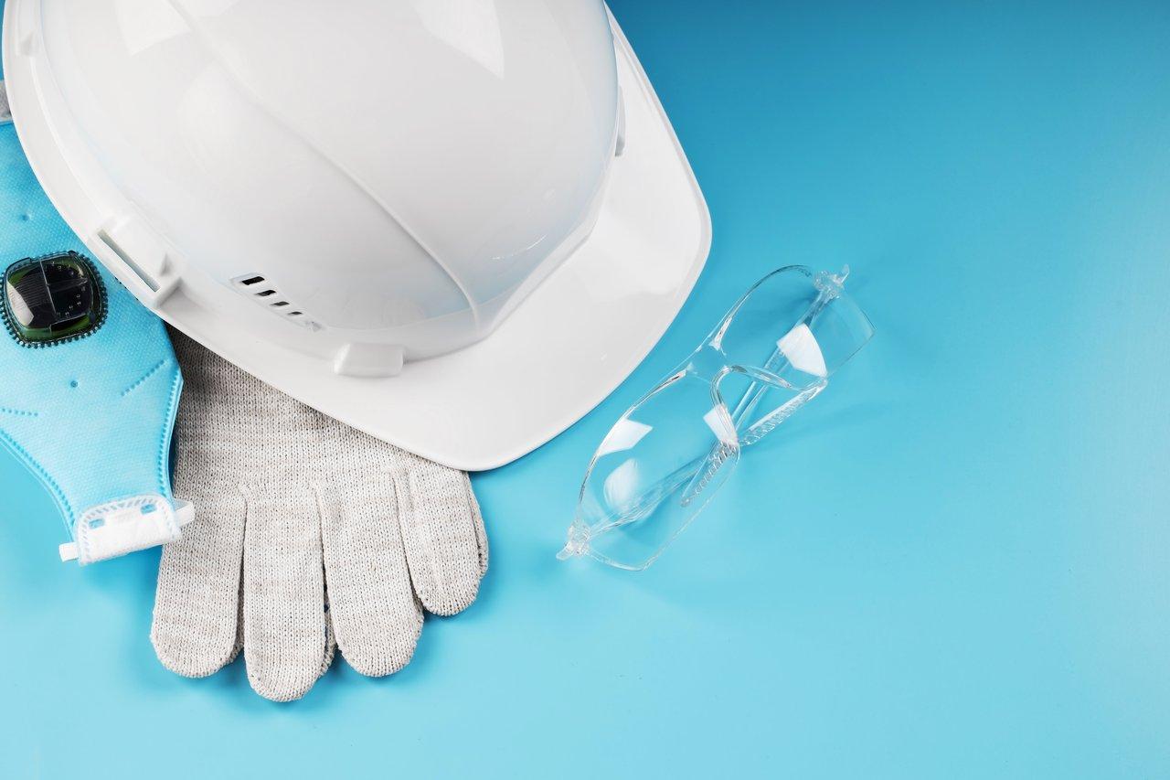 Électricien équipé de matériel de sécurité dans une zone humide balisée pour travaux électriques en toute sécurité.