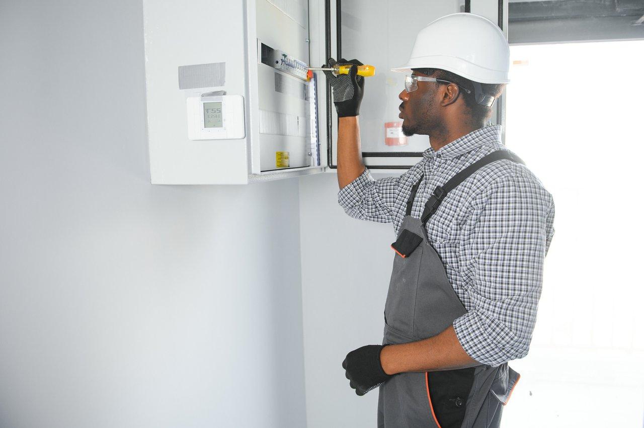 Électricien équipé d’un EPI intelligent complet avec gants connectés, casque capteur et combinaison anti-arc flash.