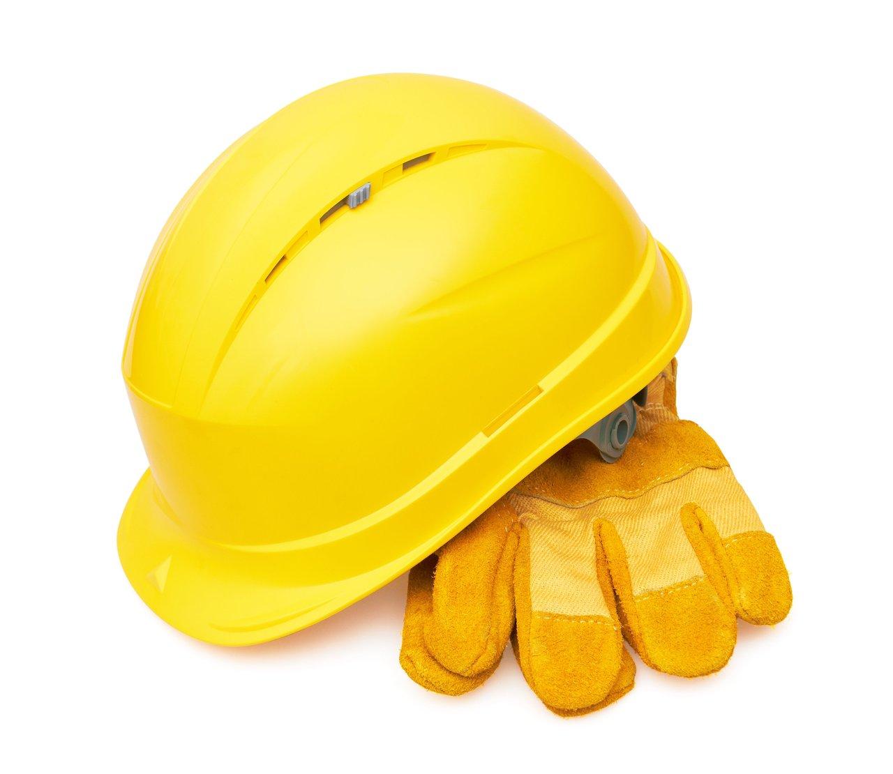 Électricien portant un équipement de protection individuelle complet, notamment casque isolant et gants isolants, sur un chantier électrique.