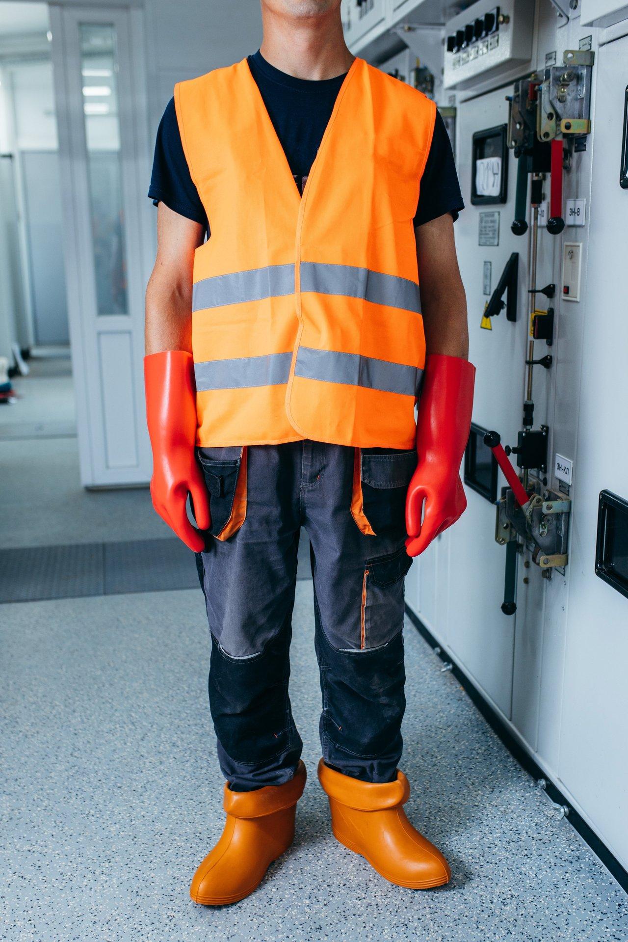 Électricien portant un vêtement ignifuge intrinsèque conforme aux normes ATPV et HRC pour une protection optimale.