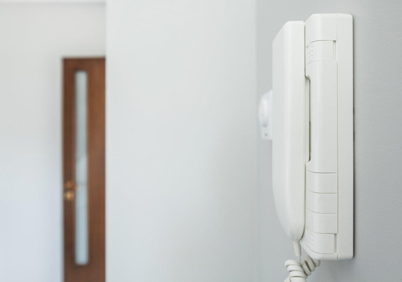 Installation d’un interphone filaire avec platine protégée solaire à 1,6 mètre pour une communication sécurisée.