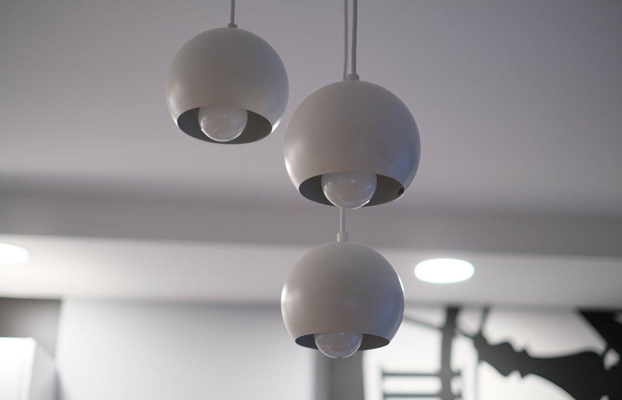 Installation d'un plafonnier déporté avec suspension ajustable pour un éclairage moderne et personnalisé.