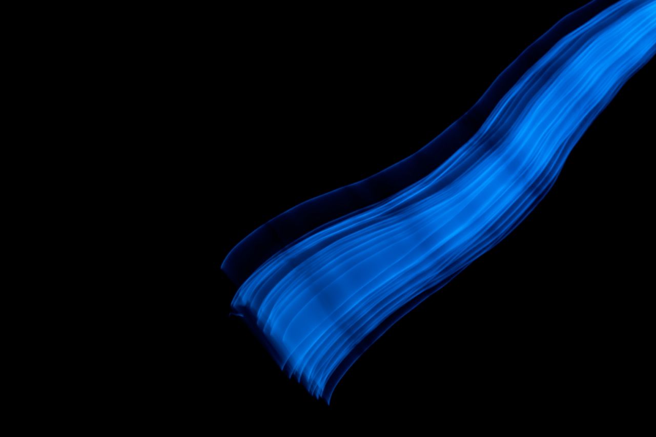 Lignes bleues abstraites lumineuses sur fond noir, design moderne idéal pour arrière-plan digital ou graphique.