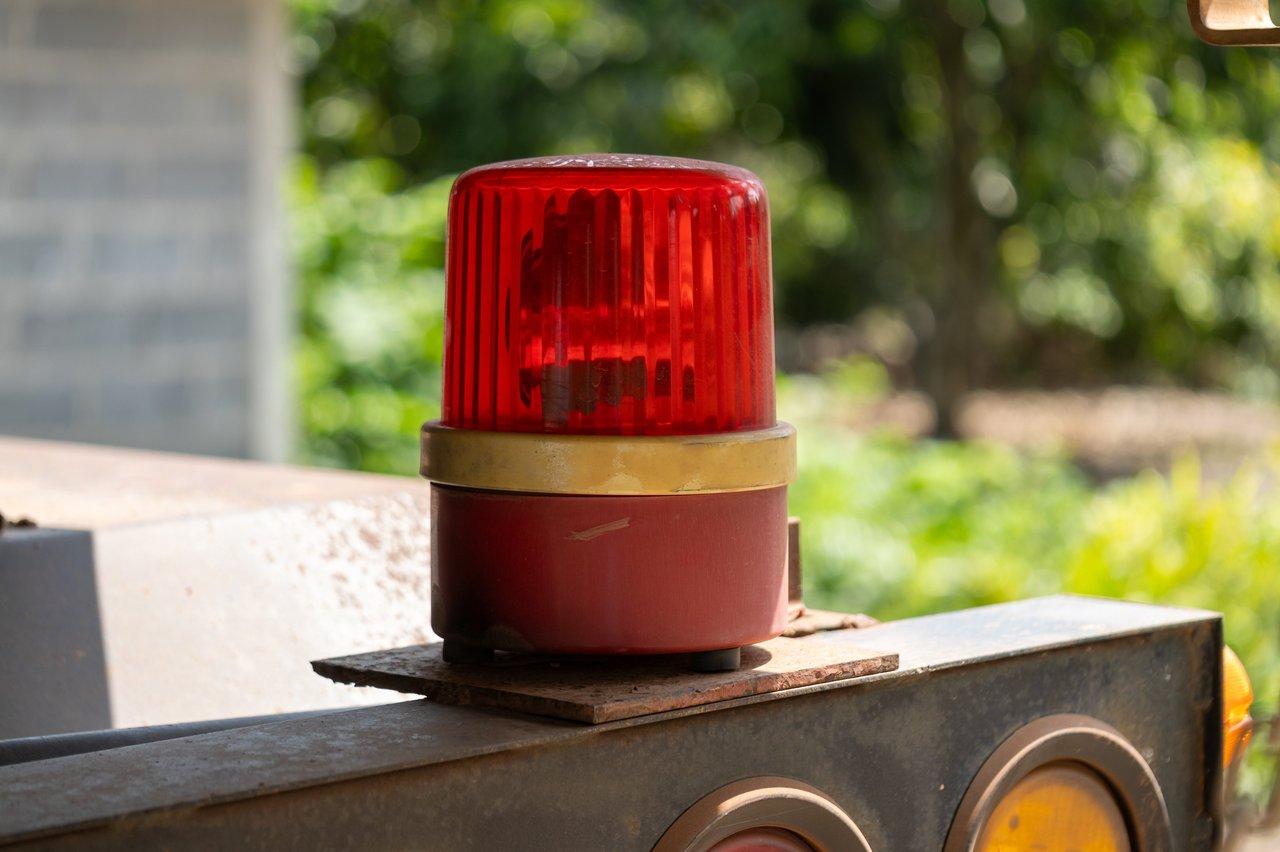 Opérateur habilité effectuant la maintenance sécurisée d’une lampe de chantier avec télécommande dans un environnement naturel.