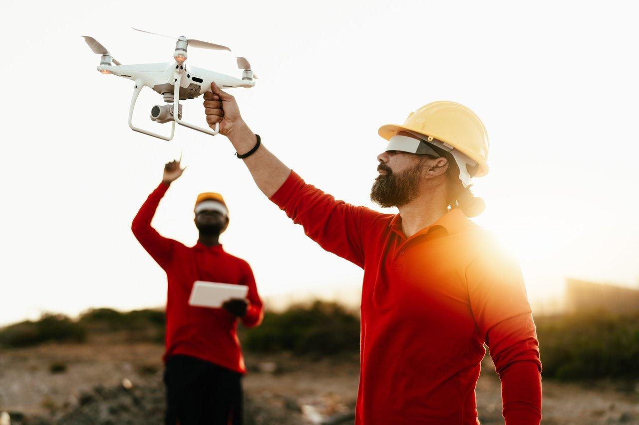 Opérateur utilisant un drone avec caméra thermique pour renforcer la sécurité sur un chantier de construction.
