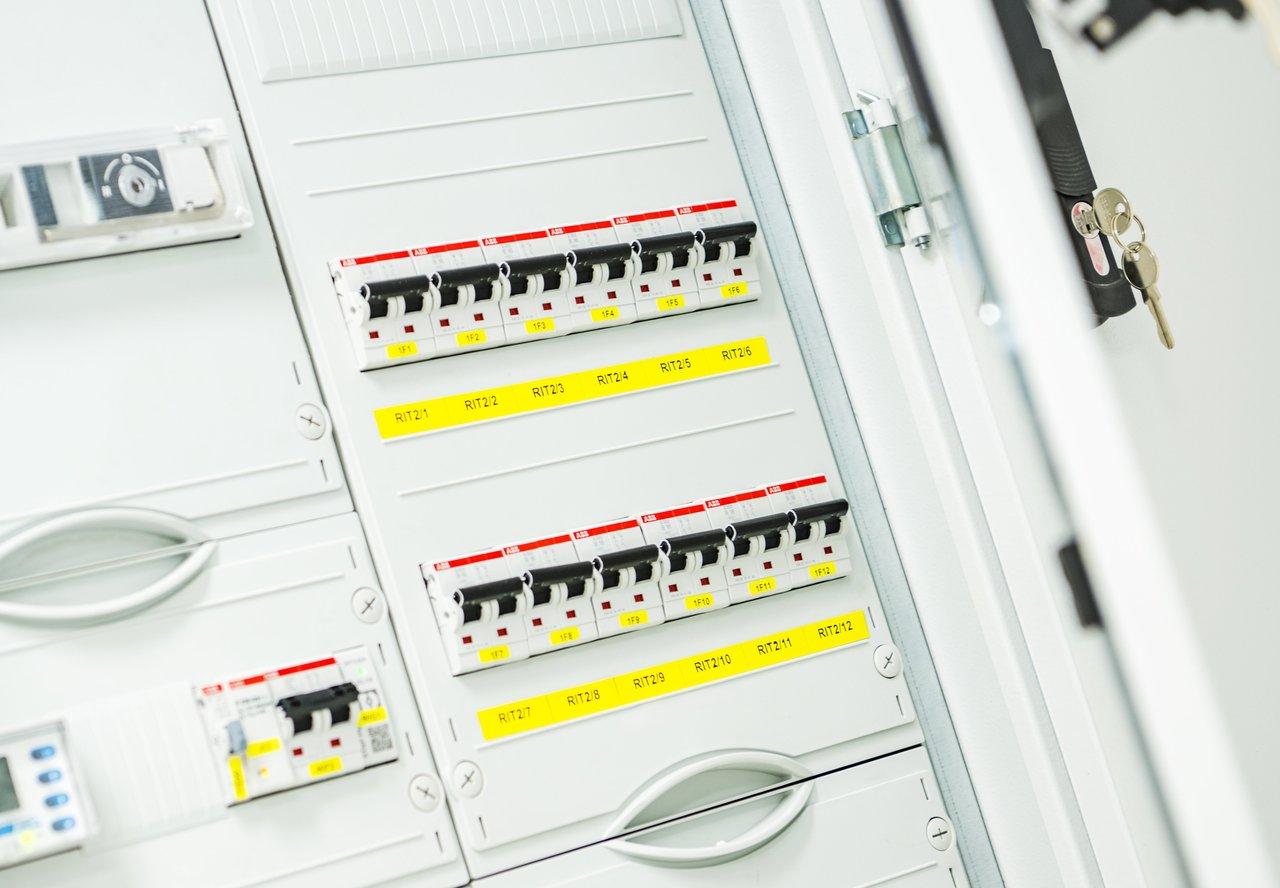 Panneau électrique avec disjoncteurs et interrupteurs différentiels dans une salle électrique bien répartie.