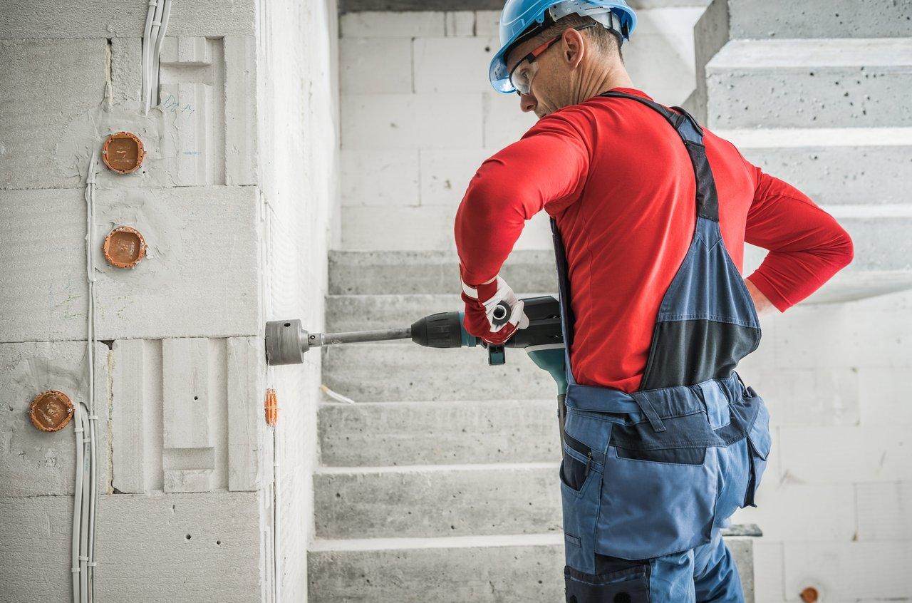 Perceuse-visseuse moderne avec batterie lithium-ion, équipée de la fonction percussion sur chantier, idéale pour vos travaux.