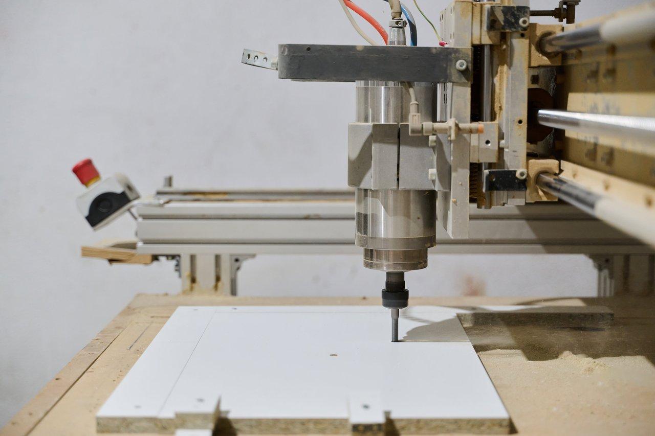 Plan de travail CNC avec martyr MDF surfacé et système de serrage intégré pour une protection optimale des outils.