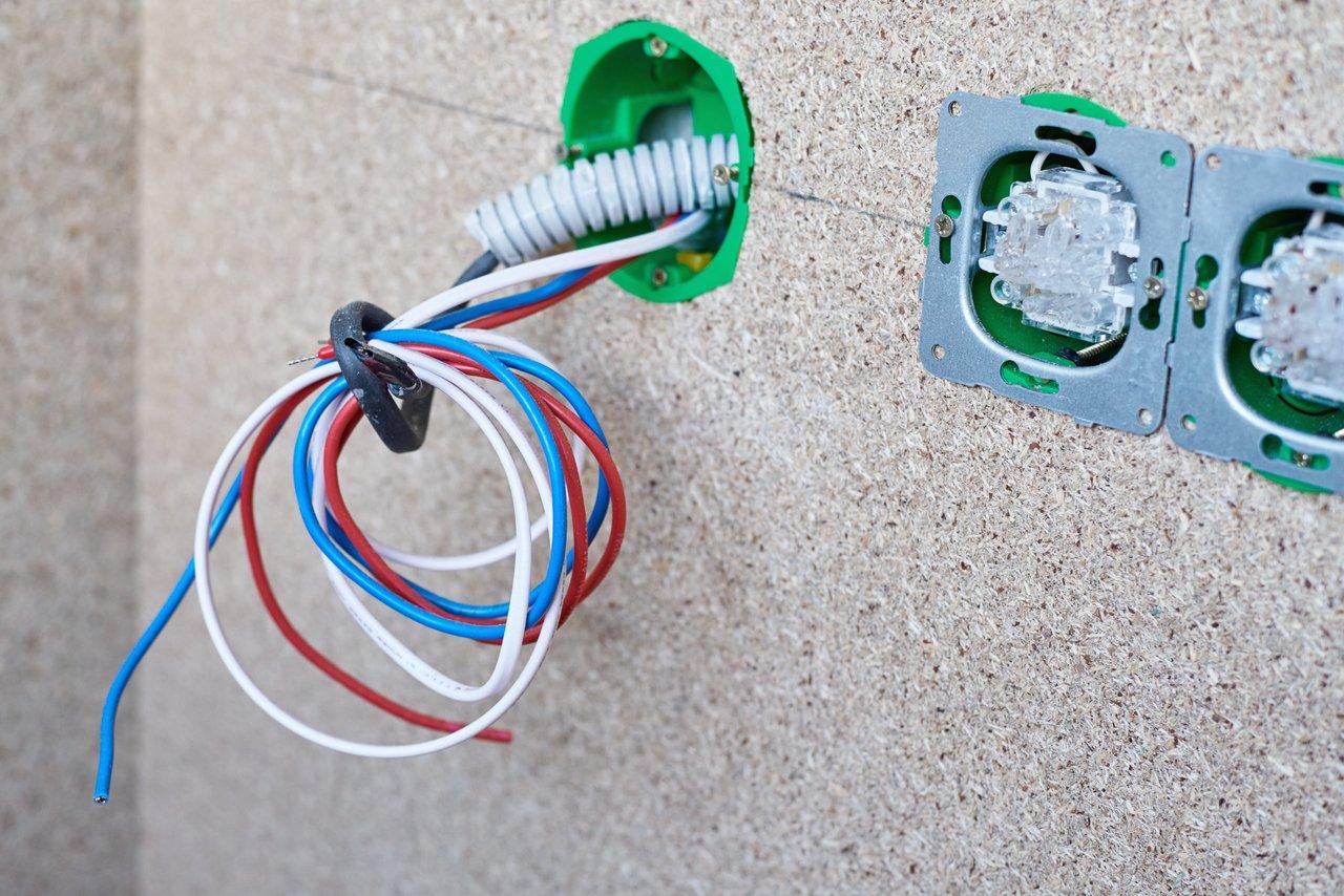 Schéma électrique couleur illustrant le montage d’un double interrupteur va-et-vient avec connexions des fils de phase, navettes et retour lampe.