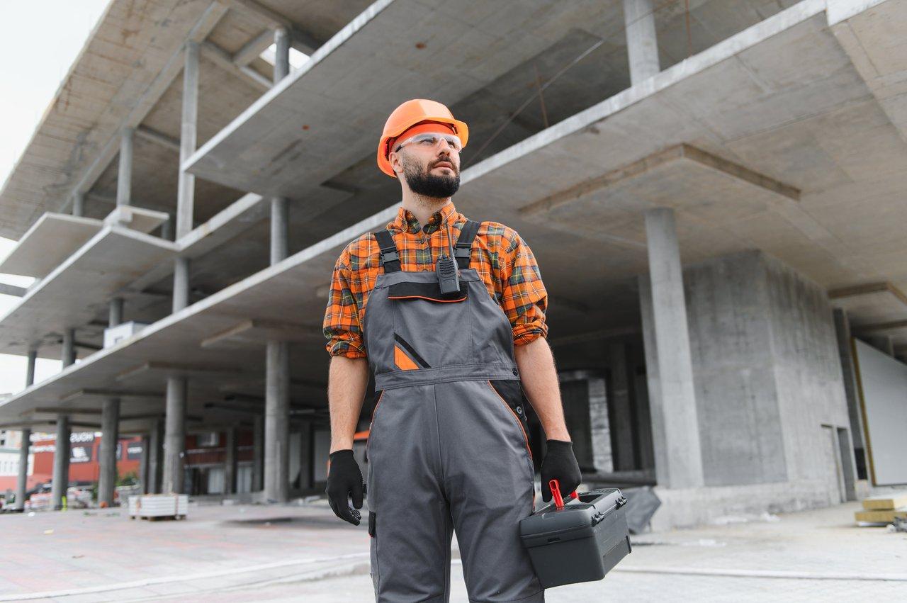 Travailleur en construction manipulant une batterie lithium-ion haute performance pour outils électroportatifs sur un chantier moderne.