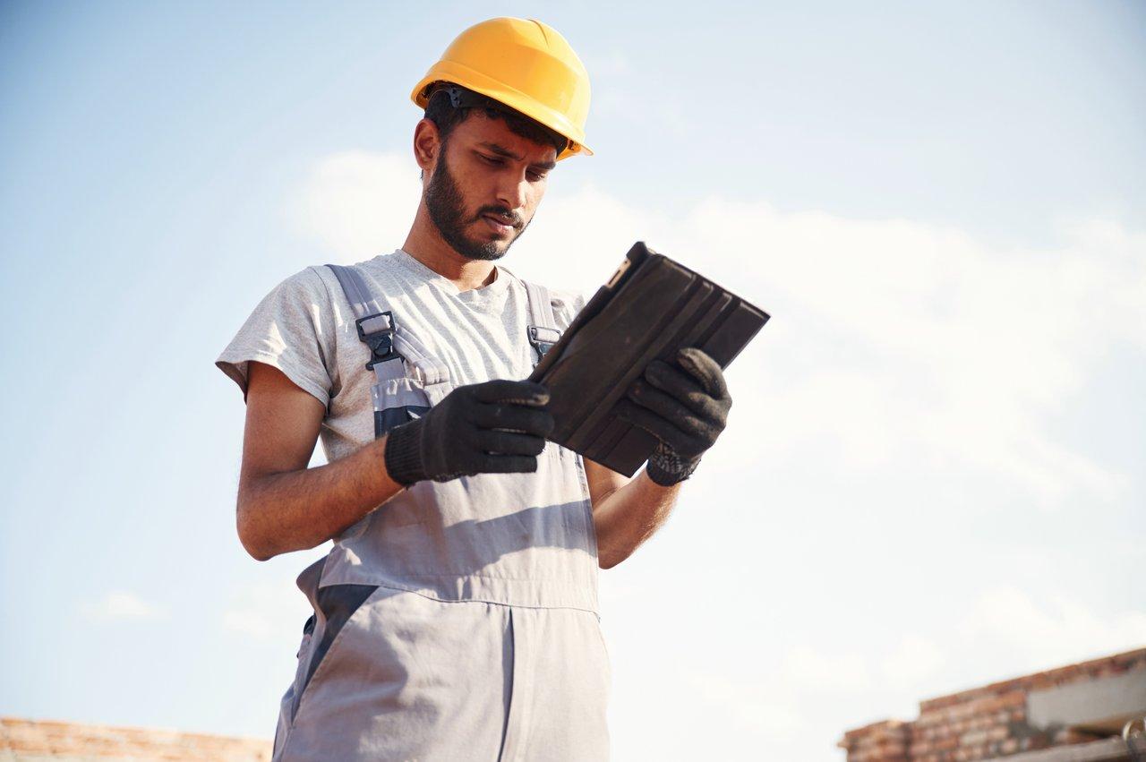 Un électricien utilise une application mobile sur tablet pour gérer efficacement son chantier et consulter des schémas.