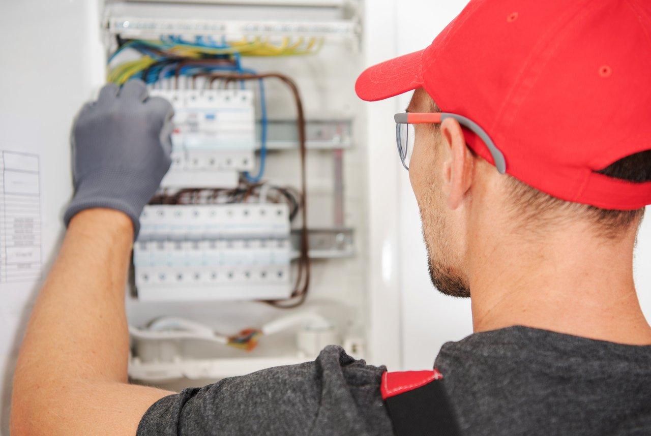 Un technicien réalise une inspection de sécurité électrique sur un panneau de disjoncteurs propre et bien entretenu.