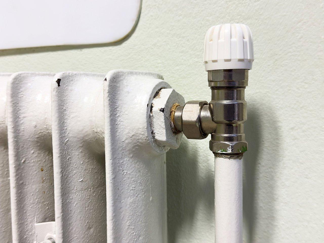 Vanne de purge d’un radiateur à eau chaude en cours de nettoyage pour optimiser le chauffage d’automne.