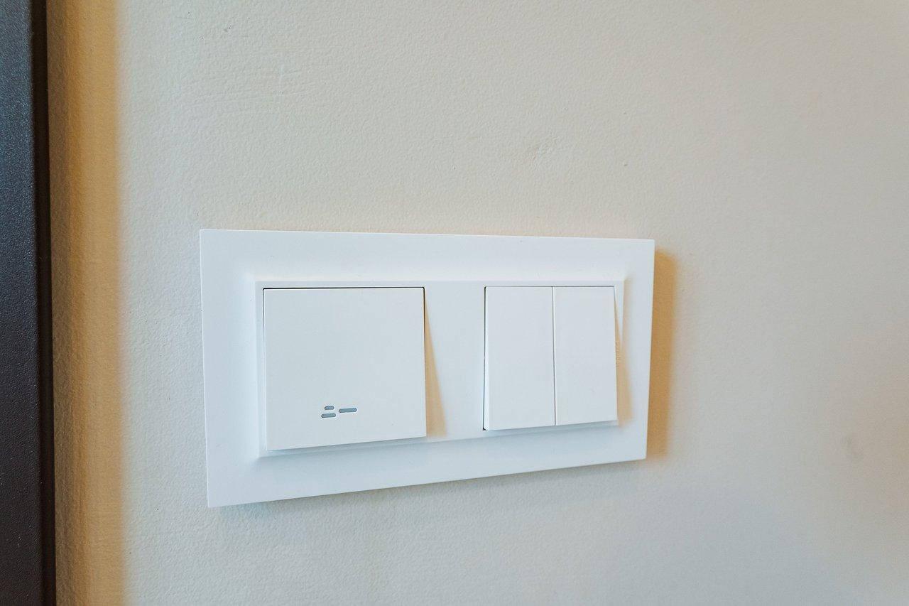 Vue détaillée du câblage d'un double interrupteur avec bornes L, 1 et 2 pour un éclairage résidentiel.